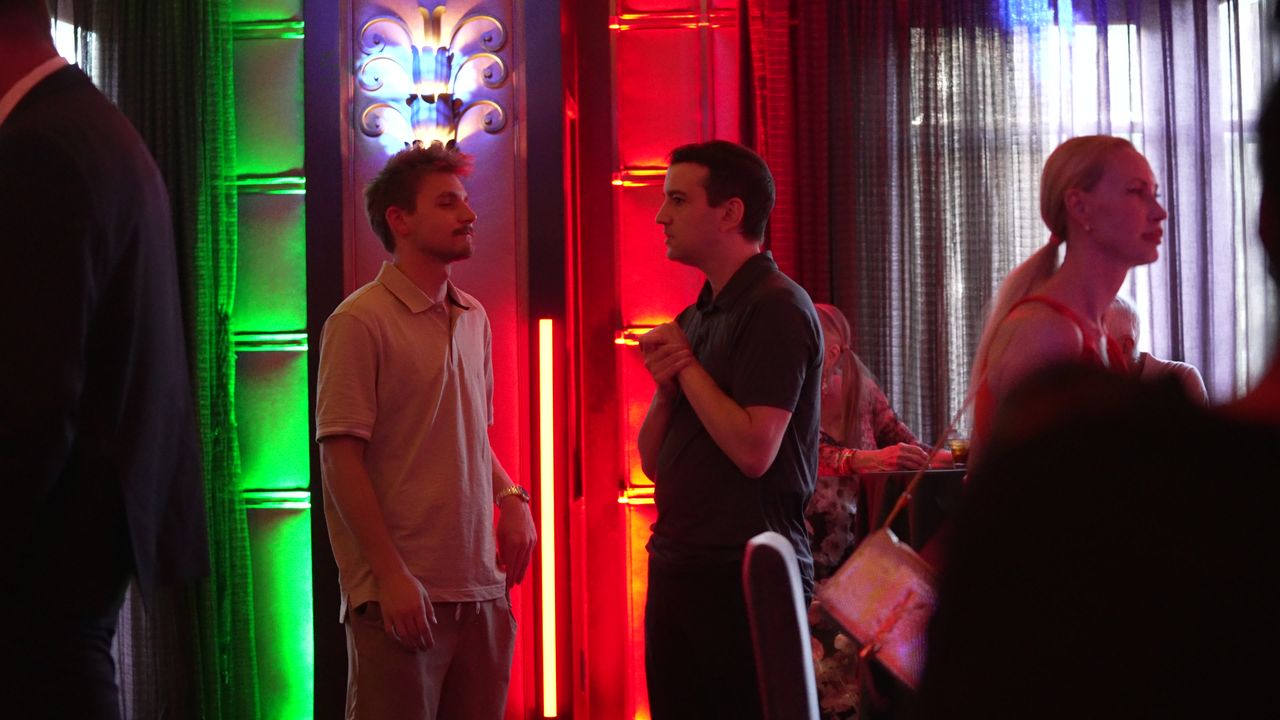 Guests talking beside the neon lit columns