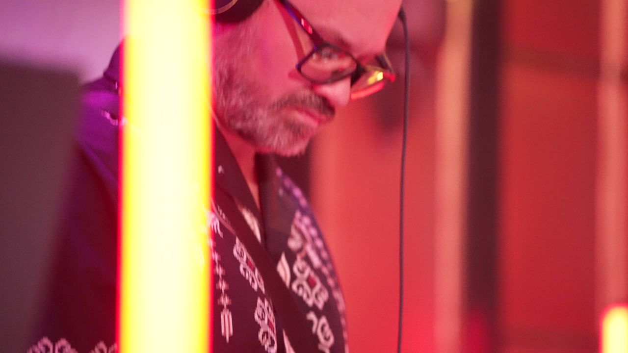 A DJ in glasses focused on the mix