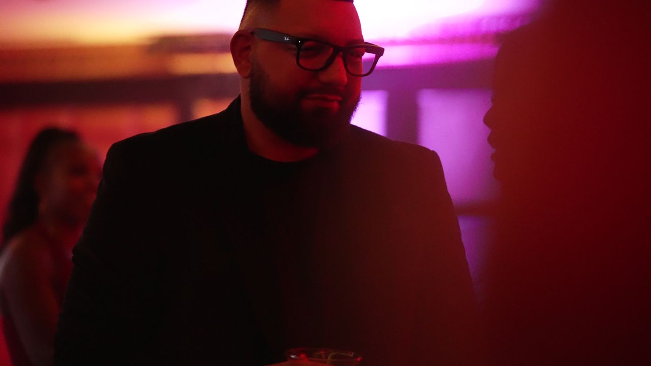 A guest in glasses under purple light