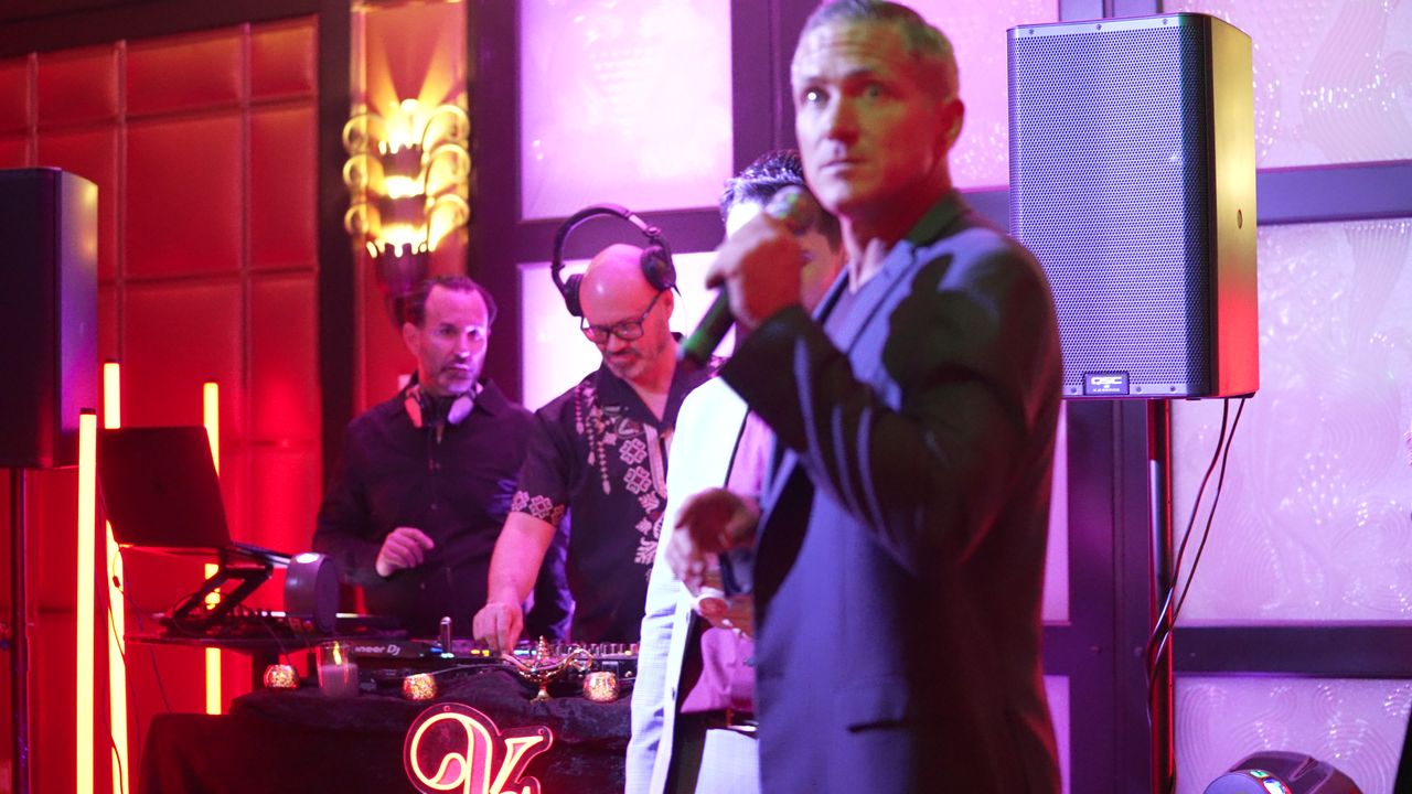 A guest speaker on the mic in front of the DJ booth