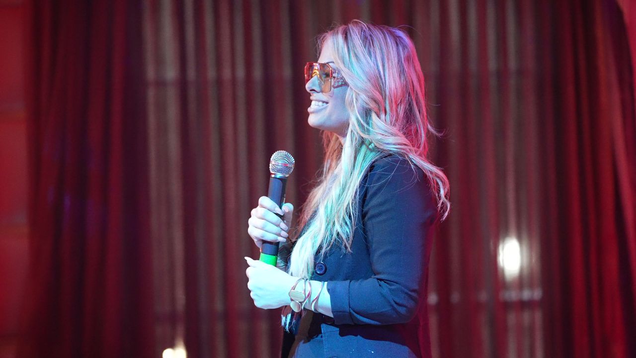 Maria Matarelli at the mic in cool blue light
